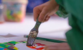 Kinderhand met schilderkwast
